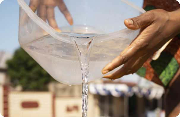 mulher negra enchendo balde de água